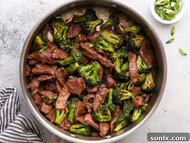Close-up shot of the Beef and Broccoli Stir Fry simmering in a pan, coated in a rich, dark sauce.