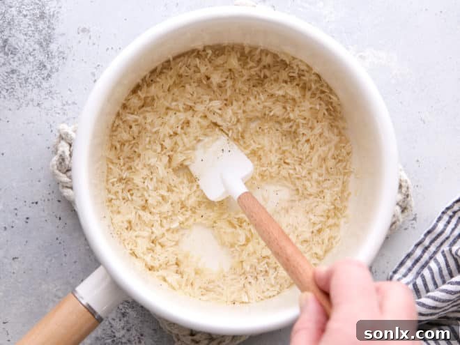 Stirring rice with olive oil, salt, and pepper in a pot