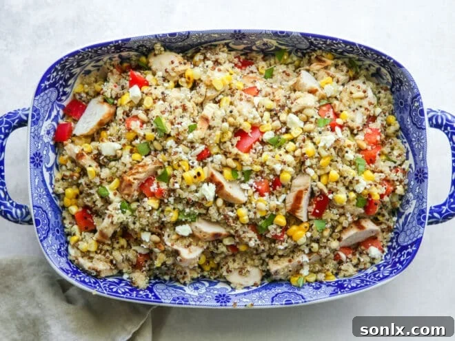 Assembled grilled chicken quinoa salad in a blue bowl, ready to serve.