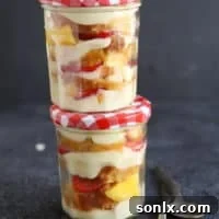 Tropical Rum Trifle with Coconut Cream in a jar, garnished with toasted coconut and macadamia nuts.