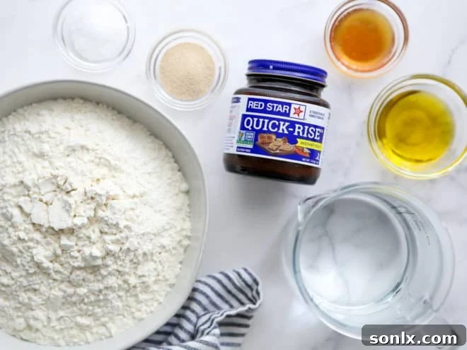 A collection of essential ingredients laid out for making easy no-knead pizza dough, including flour, yeast, olive oil, and honey.