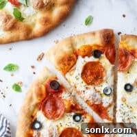 A close-up of a delicious piece of pepperoni pizza, showcasing its melted cheese and crispy crust.