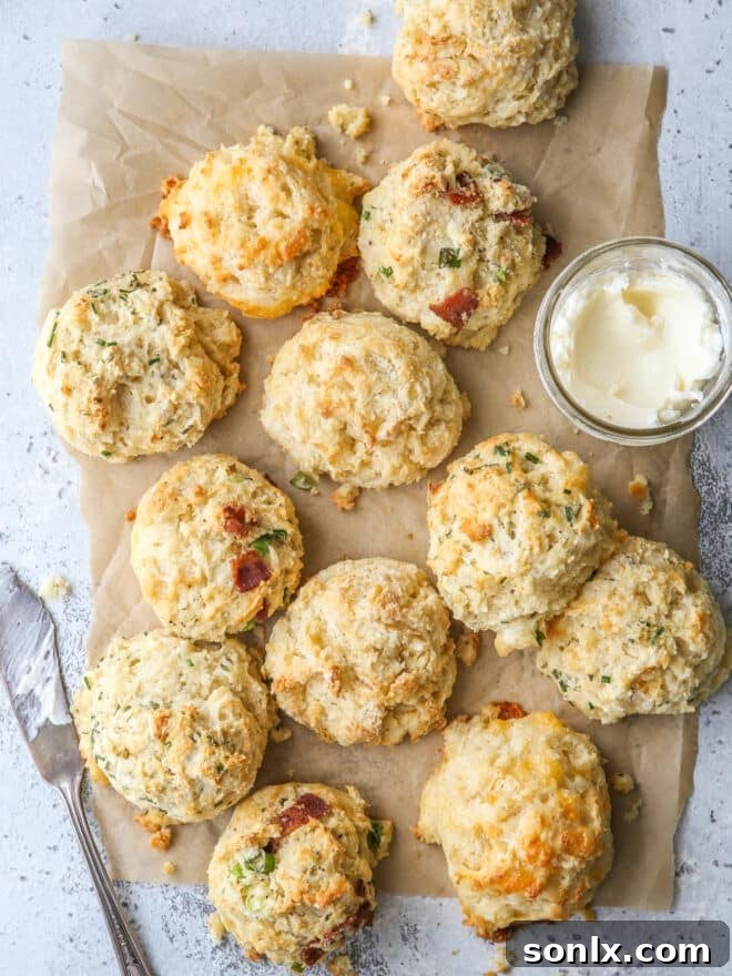 buttermilk drop biscuits with different mixins on a sheet of parchment