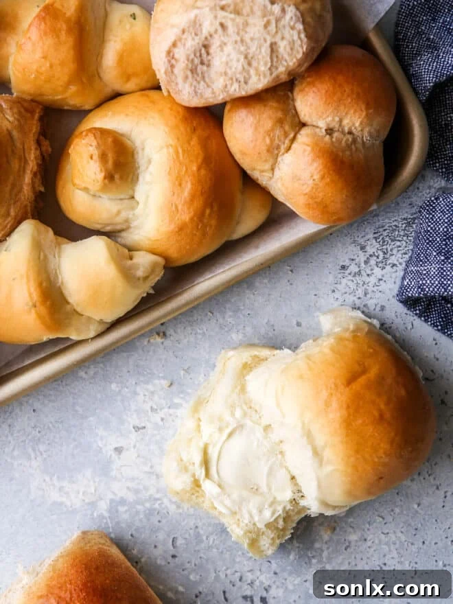 A close-up of a stack of soft, golden homemade dinner rolls