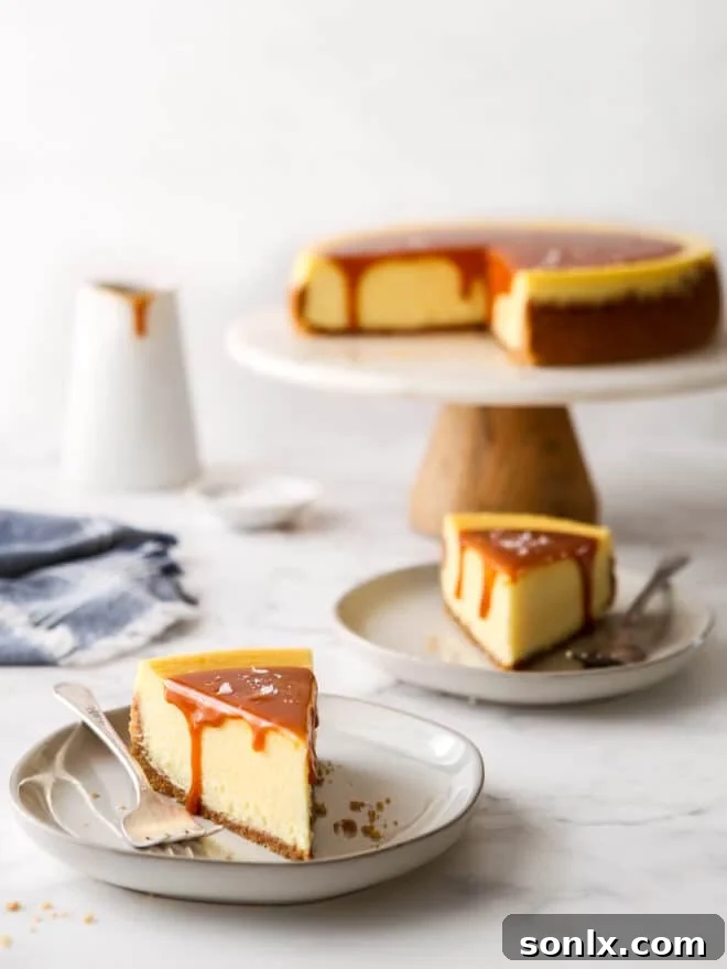 slices of salted caramel cheesecake on a plate with cake stand in background