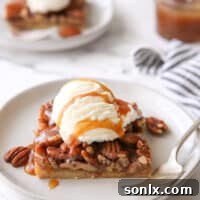 pecan pie bar with ice cream and caramel drizzle on a plate