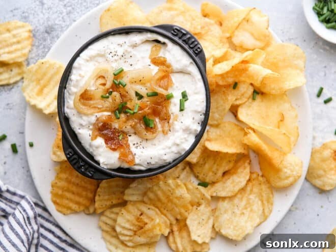 Rich Caramelized Onion Dip 3 Close-up of creamy French onion dip in a bowl with a sprinkle of fresh chives.