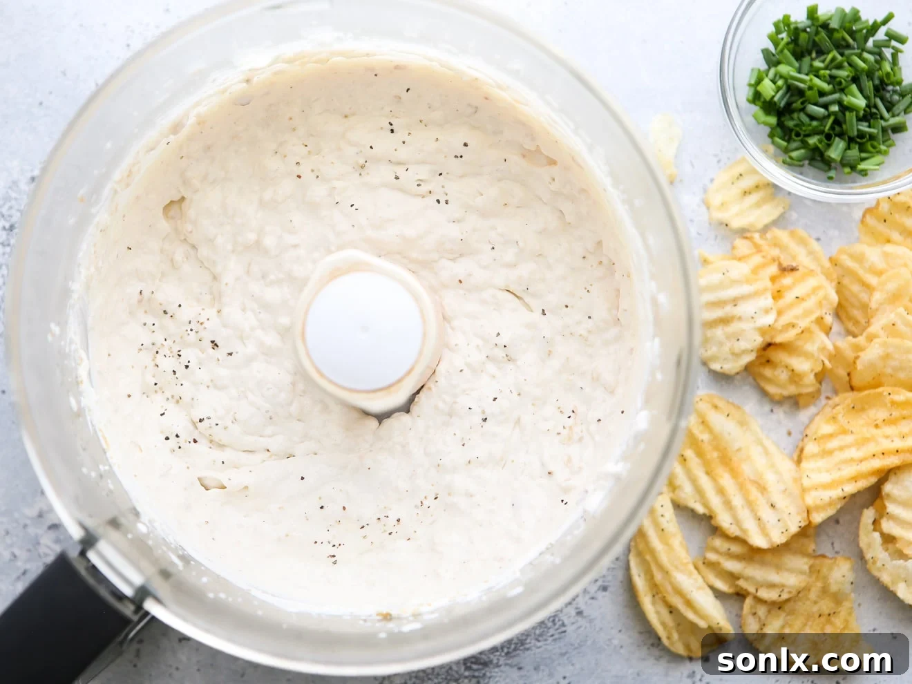 Rich Caramelized Onion Dip 6 Creamy French onion dip being blended to perfection in a food processor.