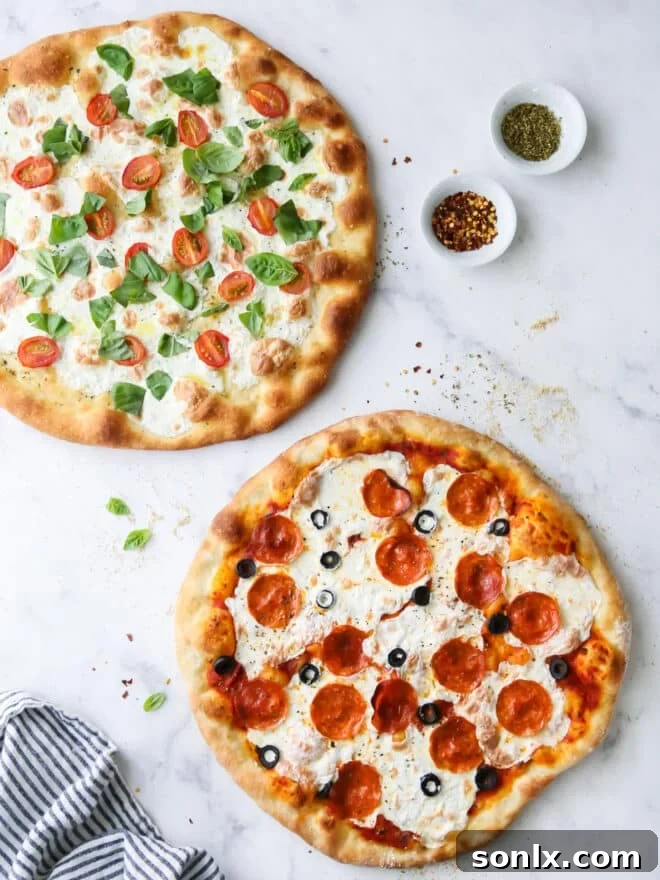 Two freshly baked pizzas, one pepperoni and one caprese, perfectly cooked and ready to be sliced, inviting a homemade pizza night.