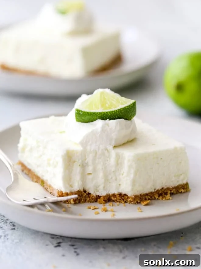 A refreshing lime cheesecake bar with a bite taken out, showcasing its vibrant green color and graham cracker crust.