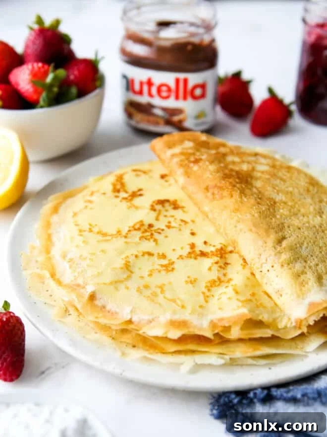 a stack of homemade crepes on a plate with toppings