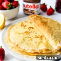 a stack of homemade crepes on a plate with toppings
