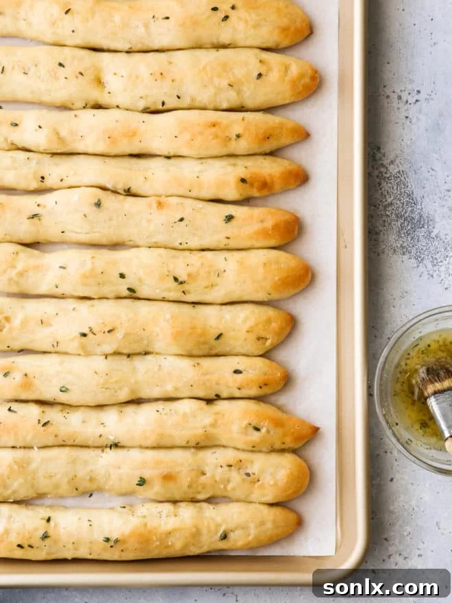 Warm breadsticks fresh from the oven, brushed with glossy garlic herb butter