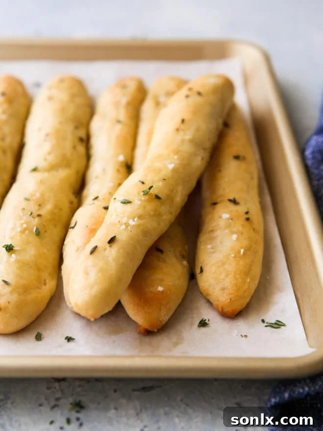 Closeup view of soft, chewy baked no-knead breadsticks with garlic herb butter