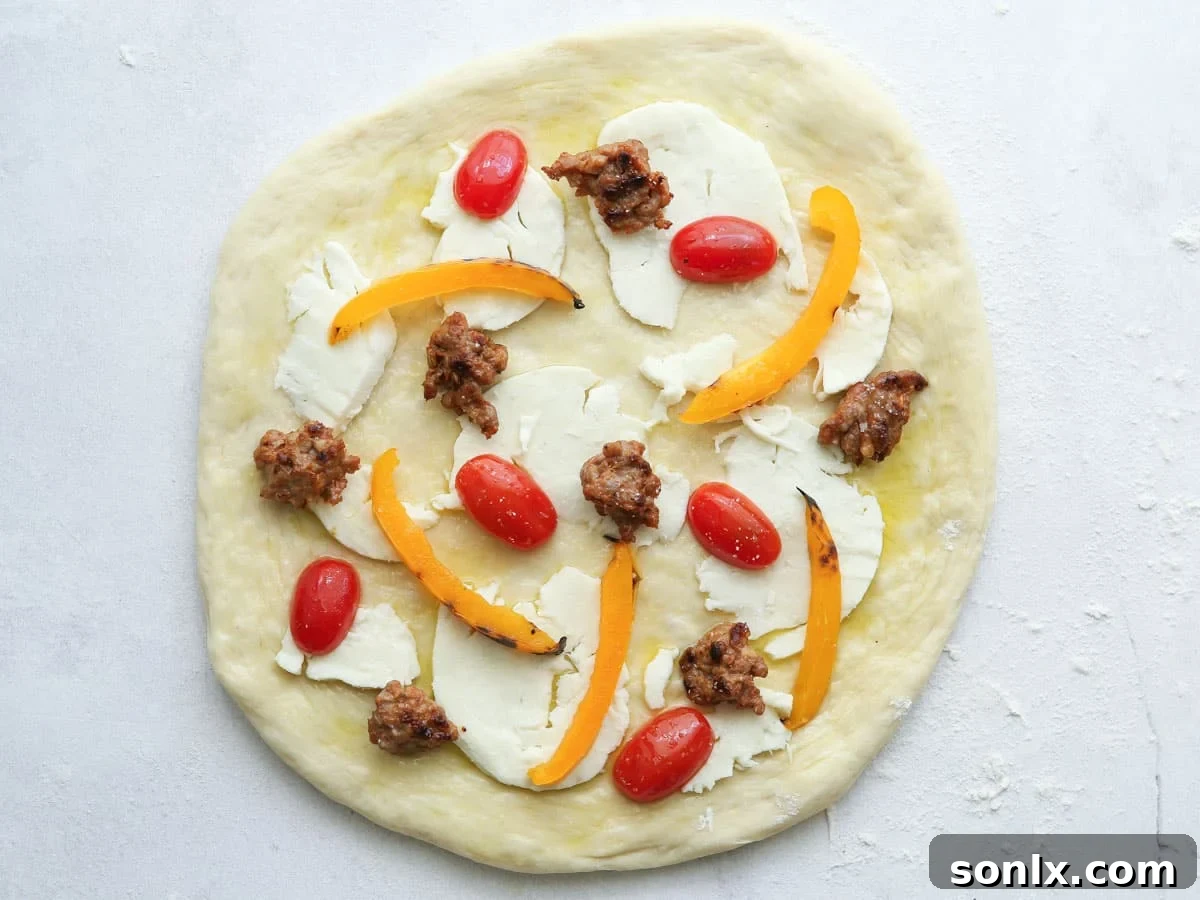 Adding fresh toppings like cheese, sausage, and peppers to raw pizza dough