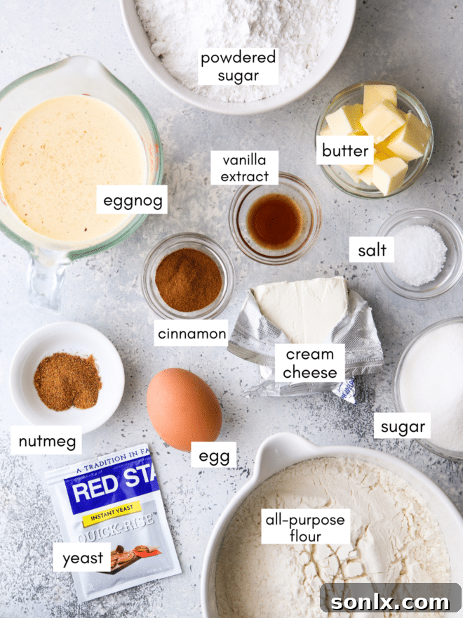 A flat lay of ingredients for eggnog cinnamon rolls, including a carton of eggnog, butter sticks, flour, eggs, and various spices.