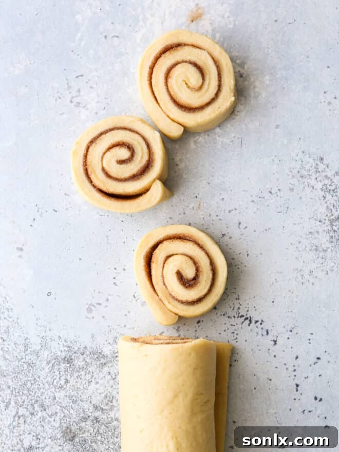 A baking dish filled with twelve perfectly baked eggnog cinnamon rolls, ready for frosting.