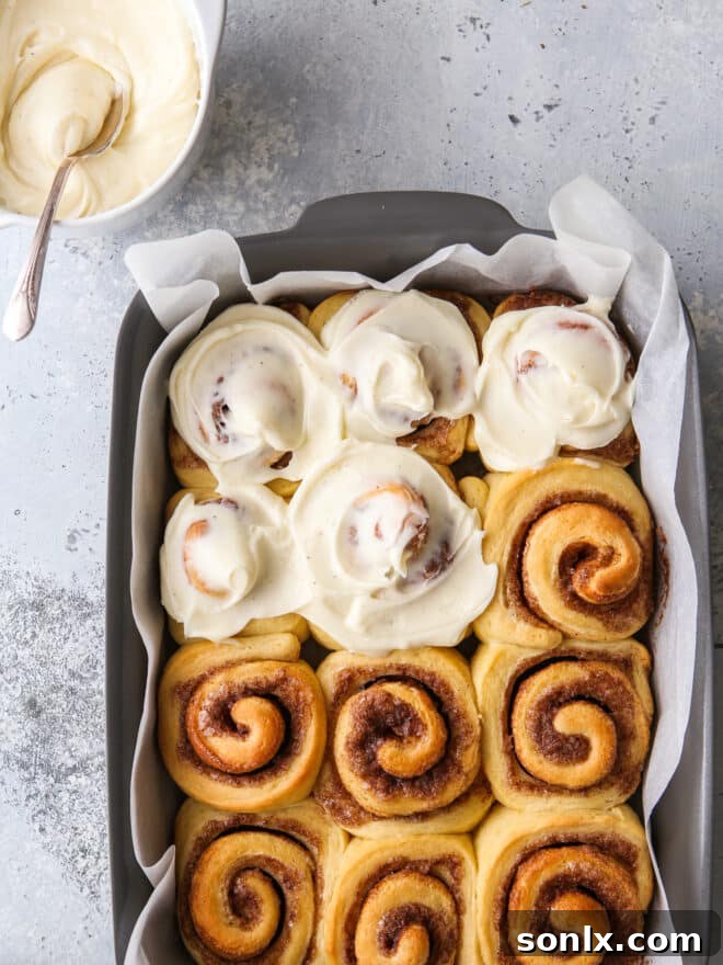A delectable spread of Eggnog Cinnamon Rolls, generously topped with cream cheese icing, artfully arranged on a serving plate.