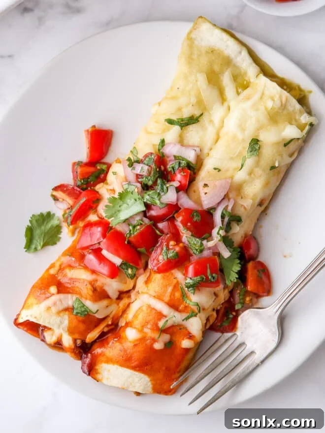 Close-up of two red and green chicken enchiladas on a plate, highlighting the textures and vibrant colors.