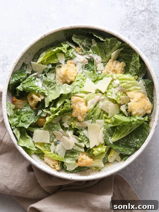 A vibrant and appetizing image demonstrating how to make the best homemade Caesar salad, featuring crisp romaine, golden croutons, and rich dressing.