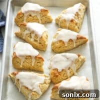 vanilla bean scones with frosting all on a baking sheet pan