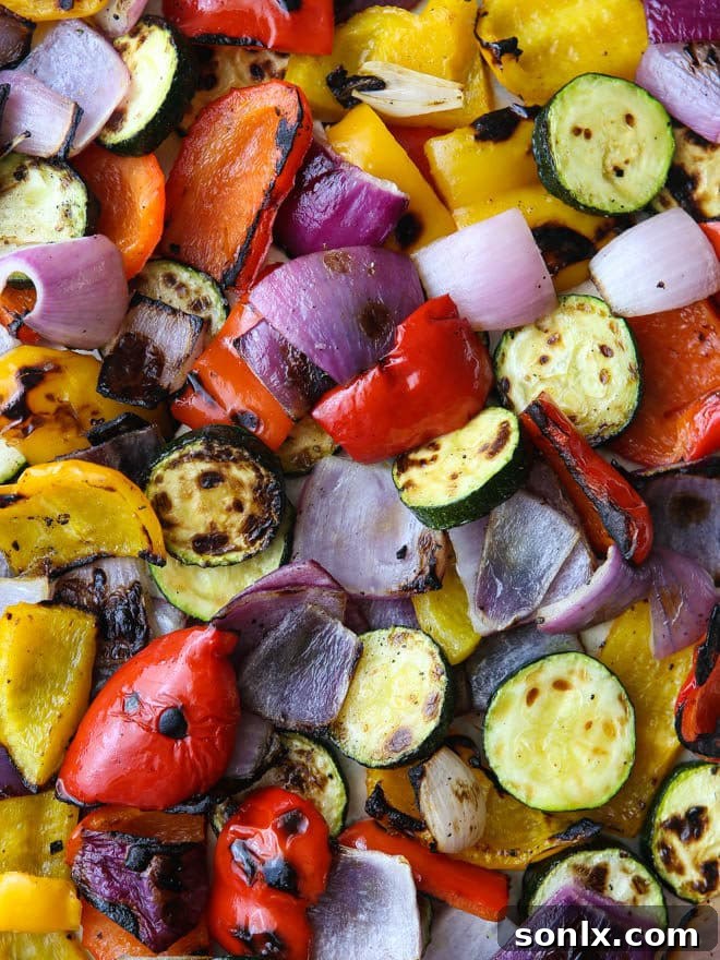 Grilled chicken pieces with mixed charred vegetables, ready for a panzanella salad.
