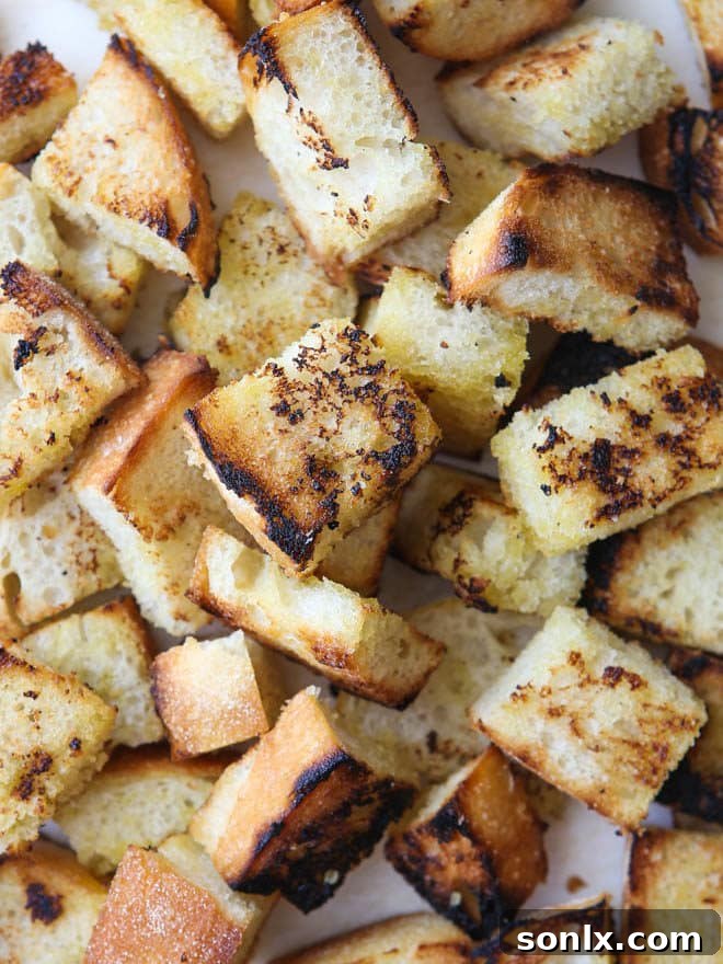 Torn artisan bread pieces with olive oil, lightly grilled for a rustic texture in the salad.