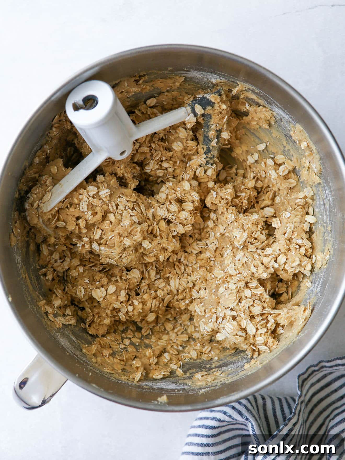 Close-up of oatmeal cookie dough in a mixing bowl after all ingredients have been combined, showcasing its rich texture.