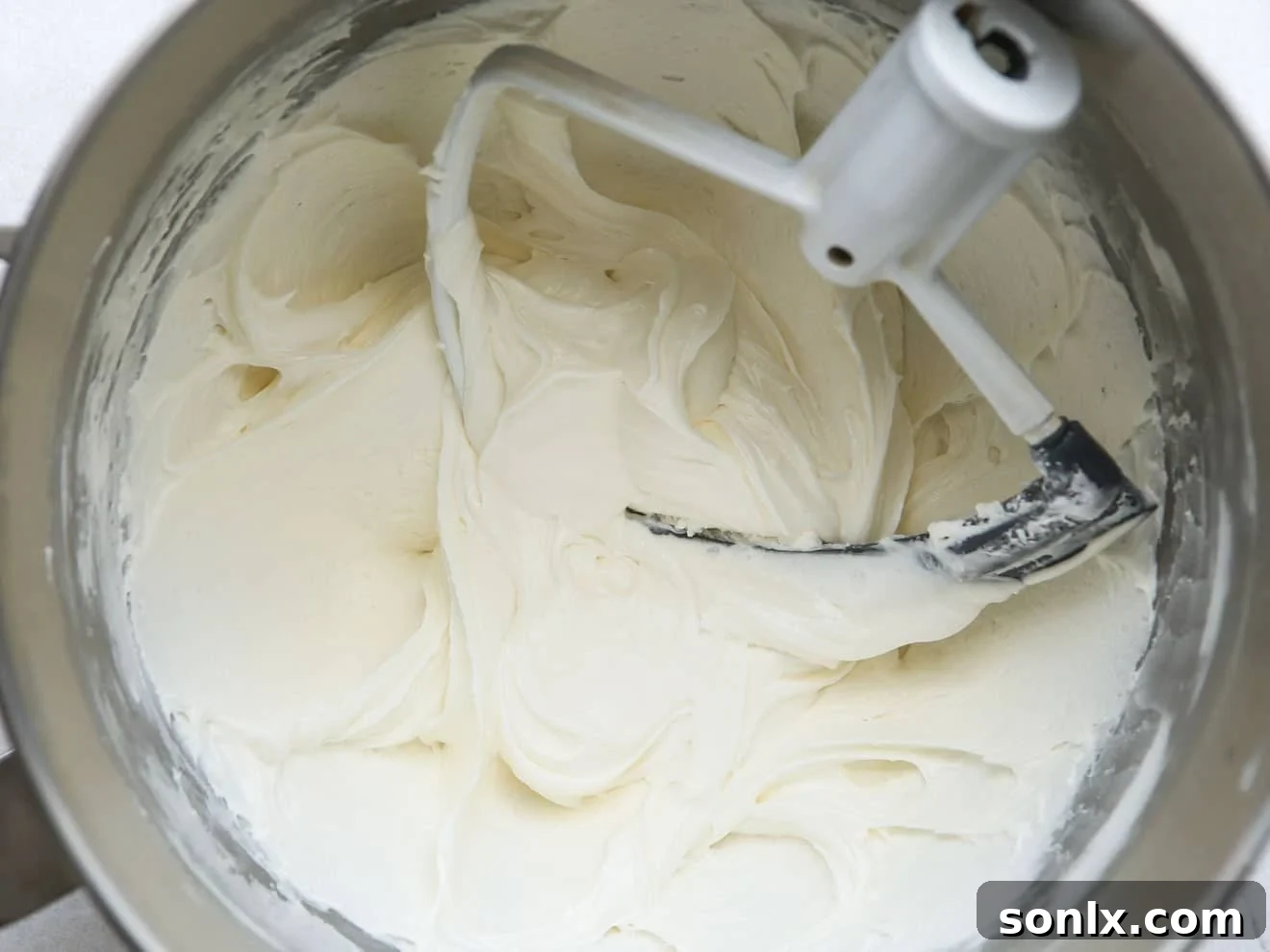 Close-up of the marshmallow cream frosting in a mixing bowl, showing its smooth and fluffy texture.