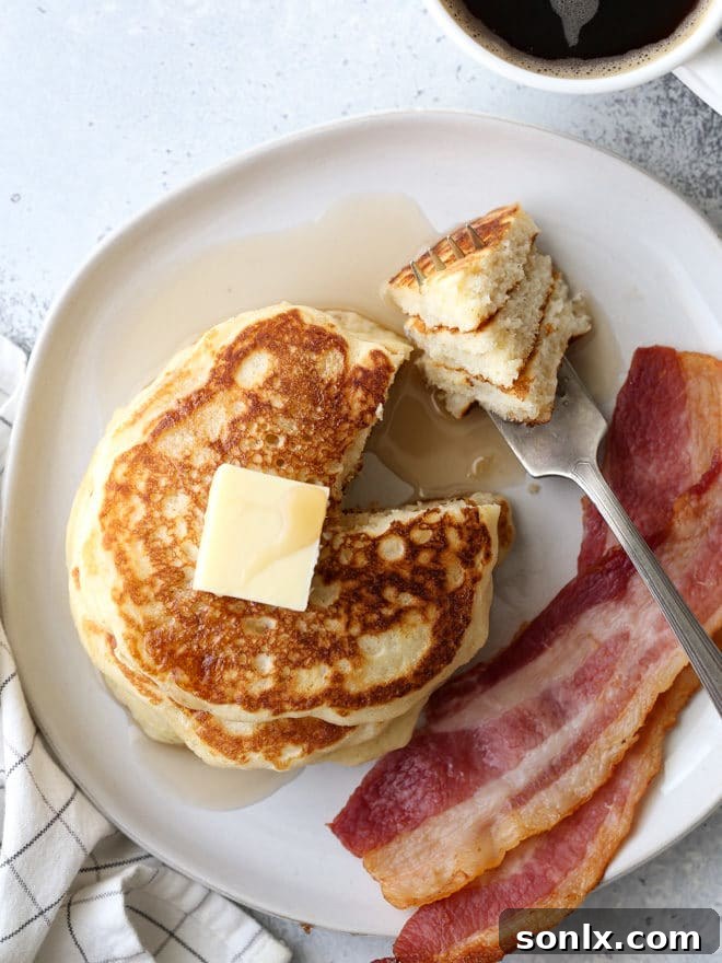 Another beautiful shot of a stack of fluffy buttermilk pancakes, showcasing their thick, tender texture and golden-brown edges.