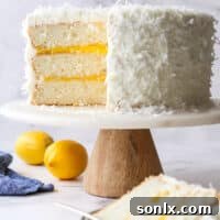 A perfectly sliced lemon coconut cake on a cake stand, ready to be served.