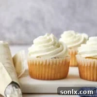 Piping elegant Chantilly cream frosting onto delicious cupcakes.
