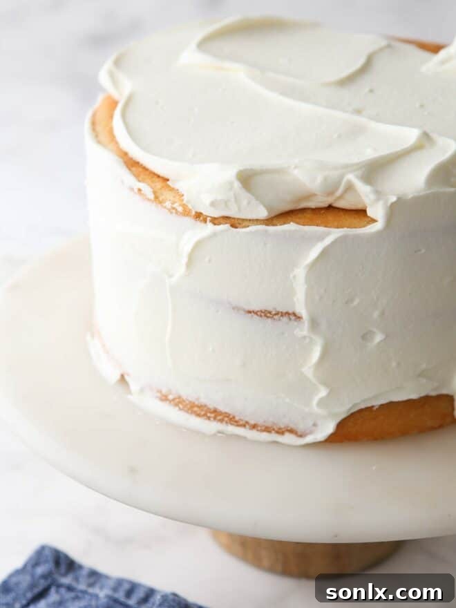 A smooth layer of Chantilly cream frosting being spread evenly on a cake.