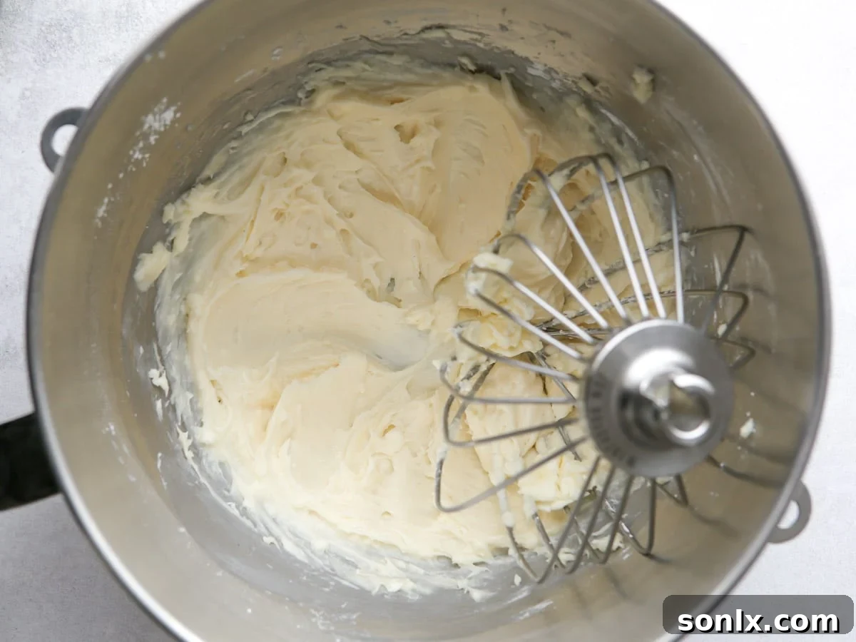 Whisking cream cheese, powdered sugar, vanilla extract, and salt together until smooth and creamy.
