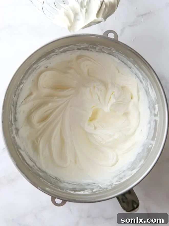 A bowl filled with beautiful, fluffy whipped Chantilly cream frosting, ready for use.