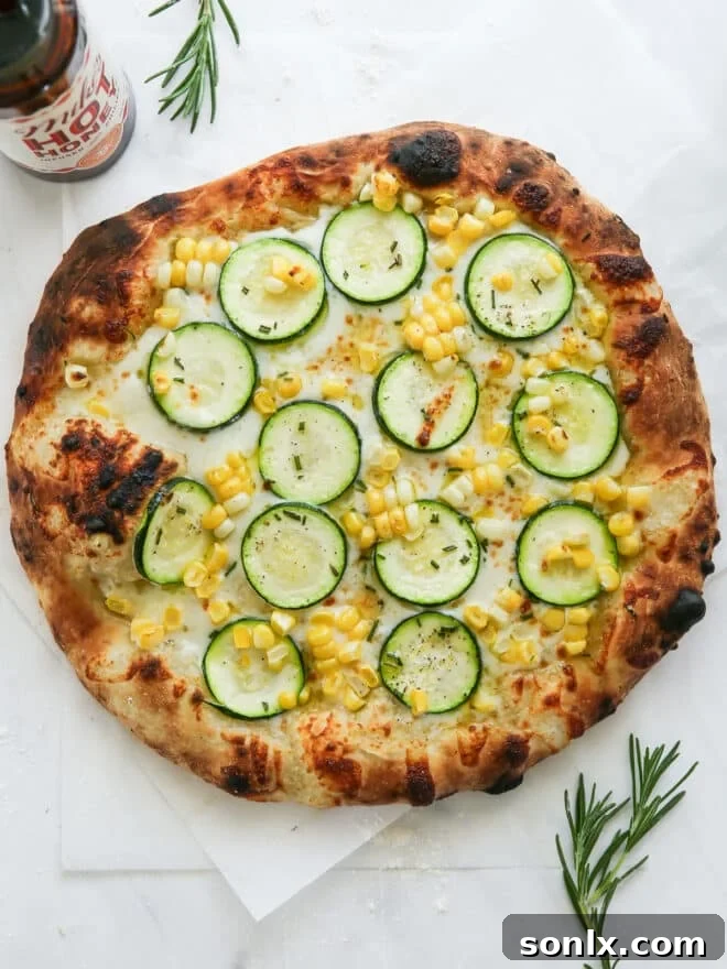 Freshly baked zucchini corn pizza resting on a kitchen counter, showcasing a golden crust and melted toppings