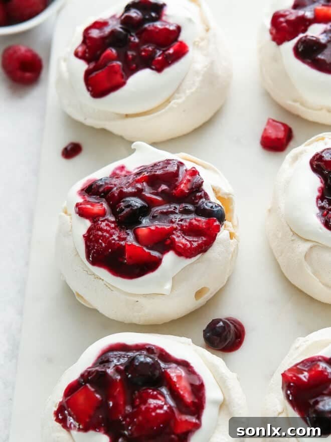 berry compote on top of pavlovas and whipped cream