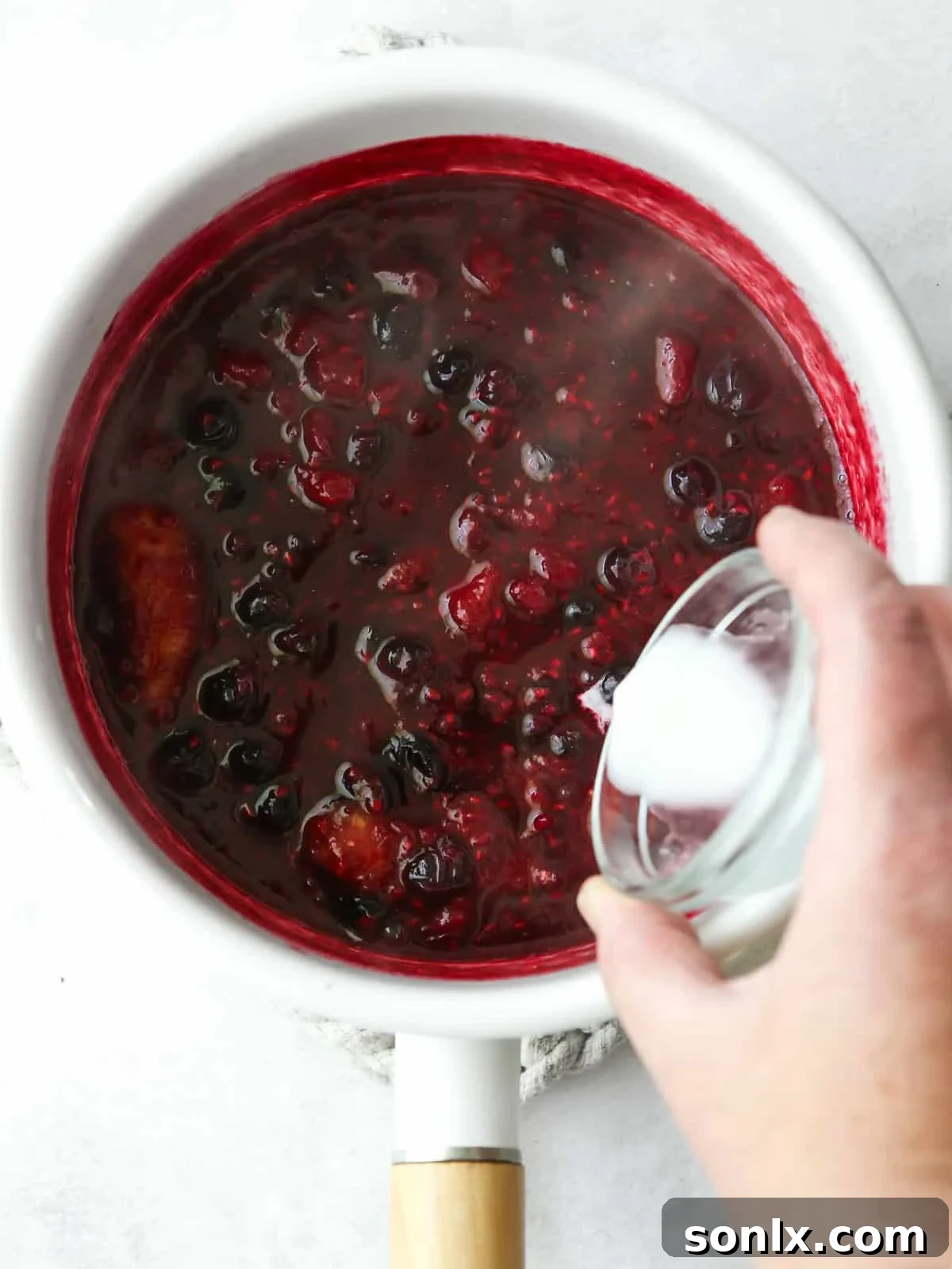 adding cornstarch slurry to berry compote
