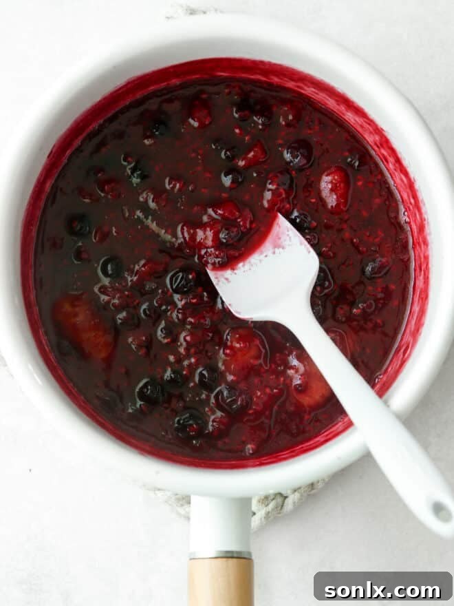 finished berry compote in a saucepan with spatula