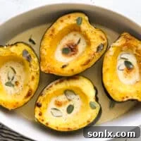roasted acorn squash with sage cream sauce in baking dish