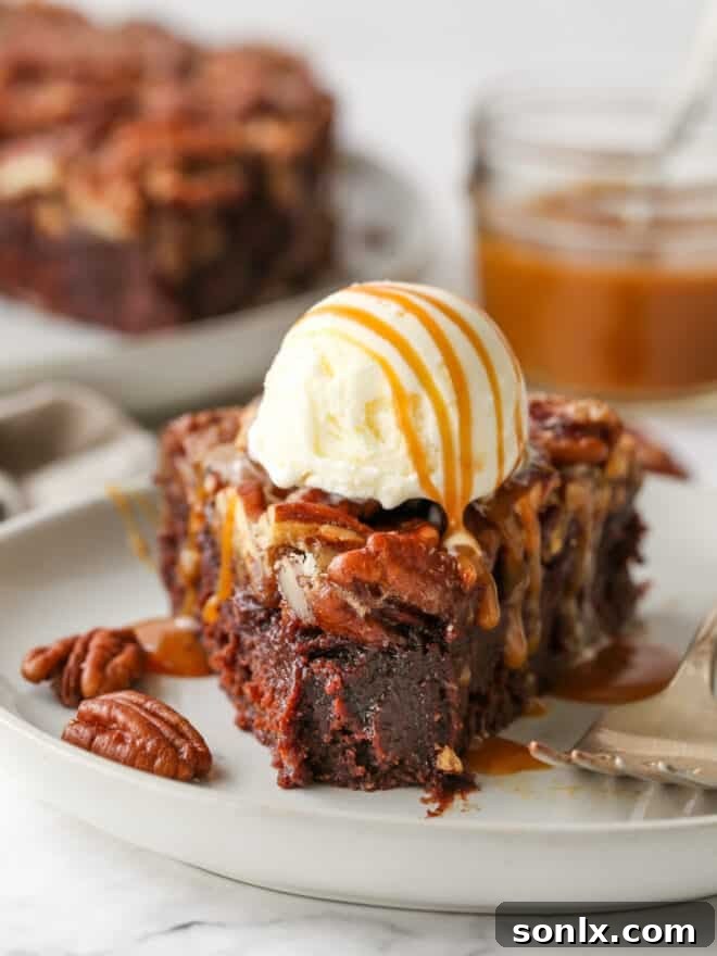 A pecan pie brownie with a bite taken out, generously topped with melting vanilla ice cream and a glossy caramel drizzle.