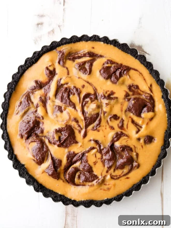 The chocolate swirl pumpkin tart, perfectly swirled and ready for baking, promising a delicious outcome.
