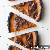 A perfectly baked Chocolate Swirl Pumpkin Tart, showcasing the distinct layers and elegant swirl of the filling.