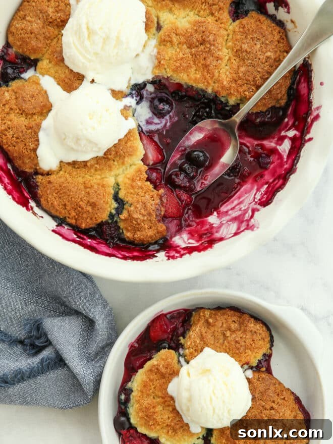 A baker scooping out a portion of warm, bubbly berry cobbler from a baking dish, ready to be served.