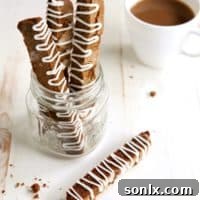 A plate of freshly baked Gingersnap Biscotti with a beautiful white chocolate drizzle, ready to serve.