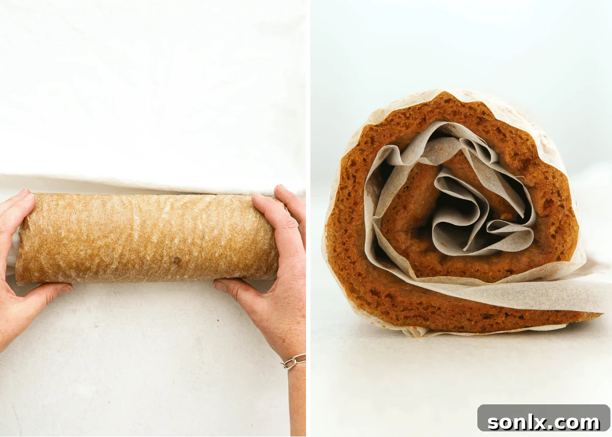 Hands carefully rolling up a hot pumpkin cake into a tight log using parchment paper and a towel.