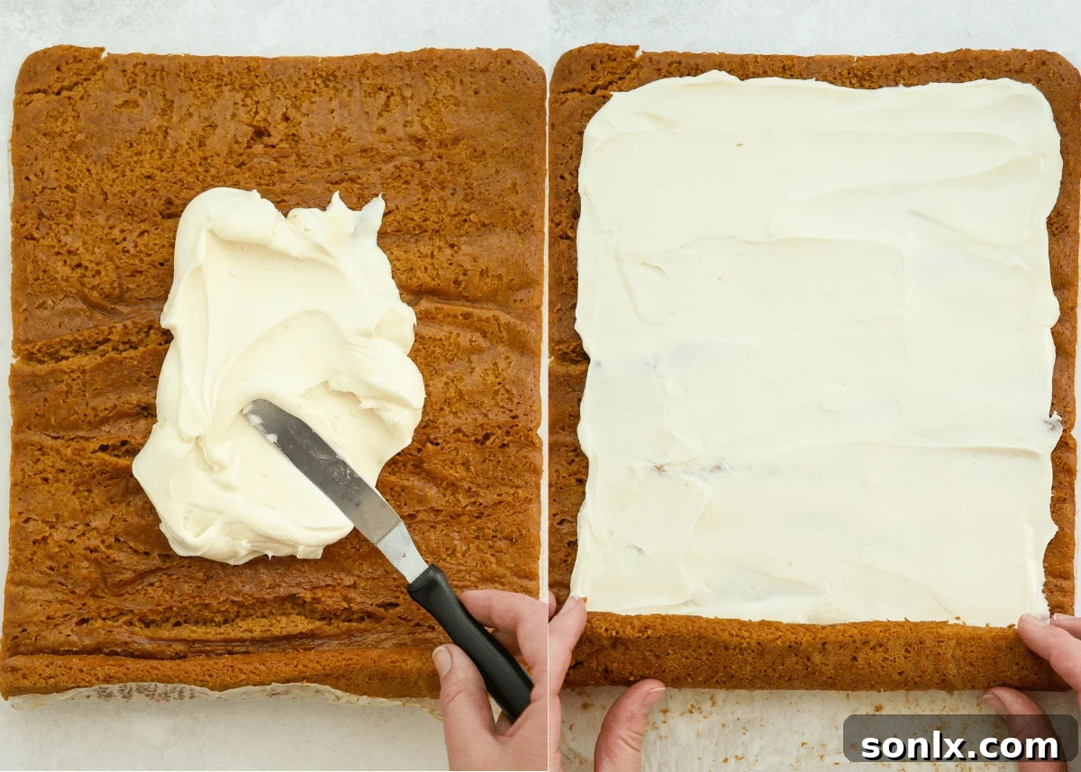 Spreading cream cheese frosting evenly over the unrolled pumpkin cake using an offset spatula.