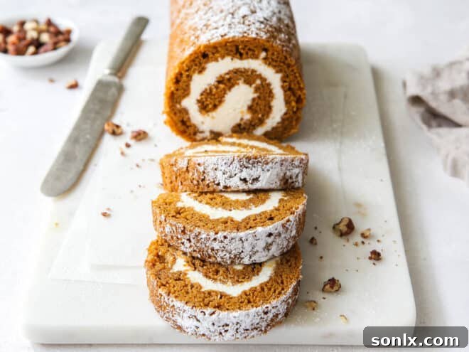 A sharp serrated knife cutting a slice from a pumpkin roll, revealing the perfect spiral.