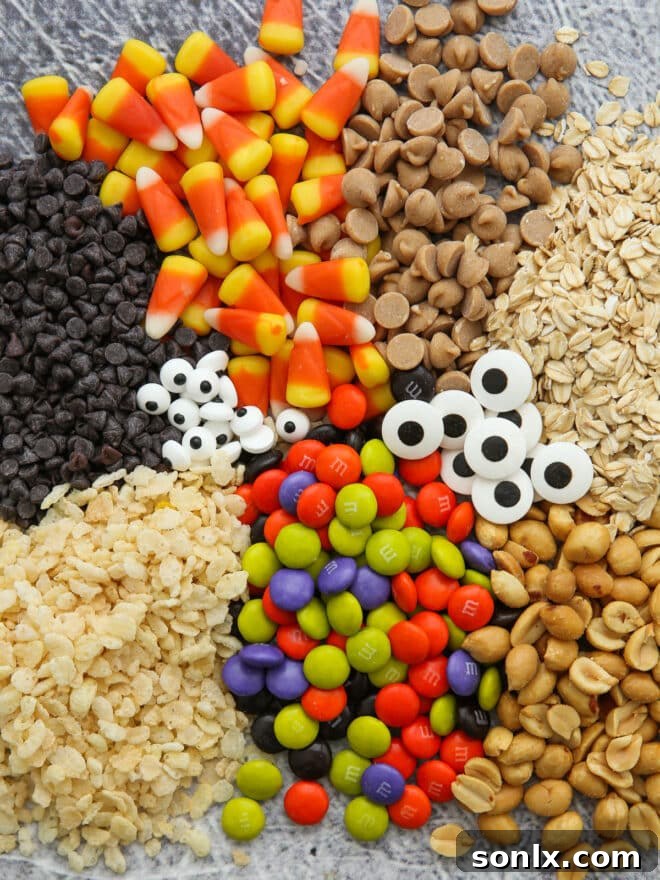 A colorful array of mix-ins for Halloween Monster Cookies: oats, chocolate chips, M&Ms, candy eyeballs, and peanuts