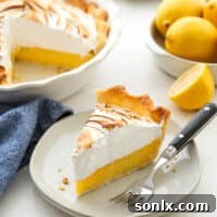 A beautifully presented slice of lemon meringue pie on a plate, ready to be enjoyed.